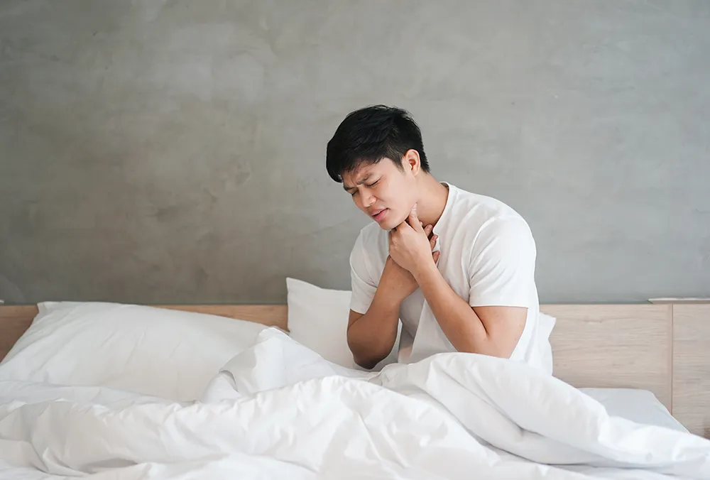 喉を痛がる男性
